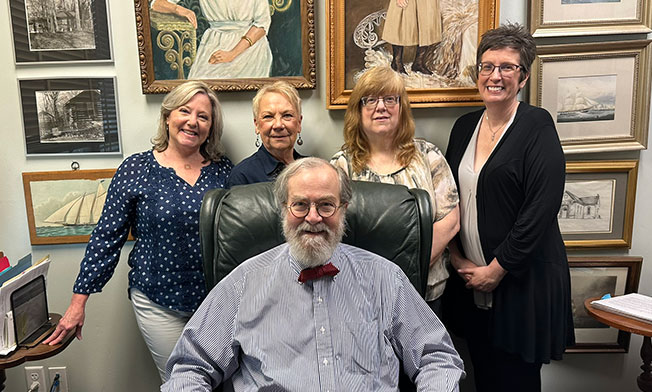 Richard seated with collection team standing behind